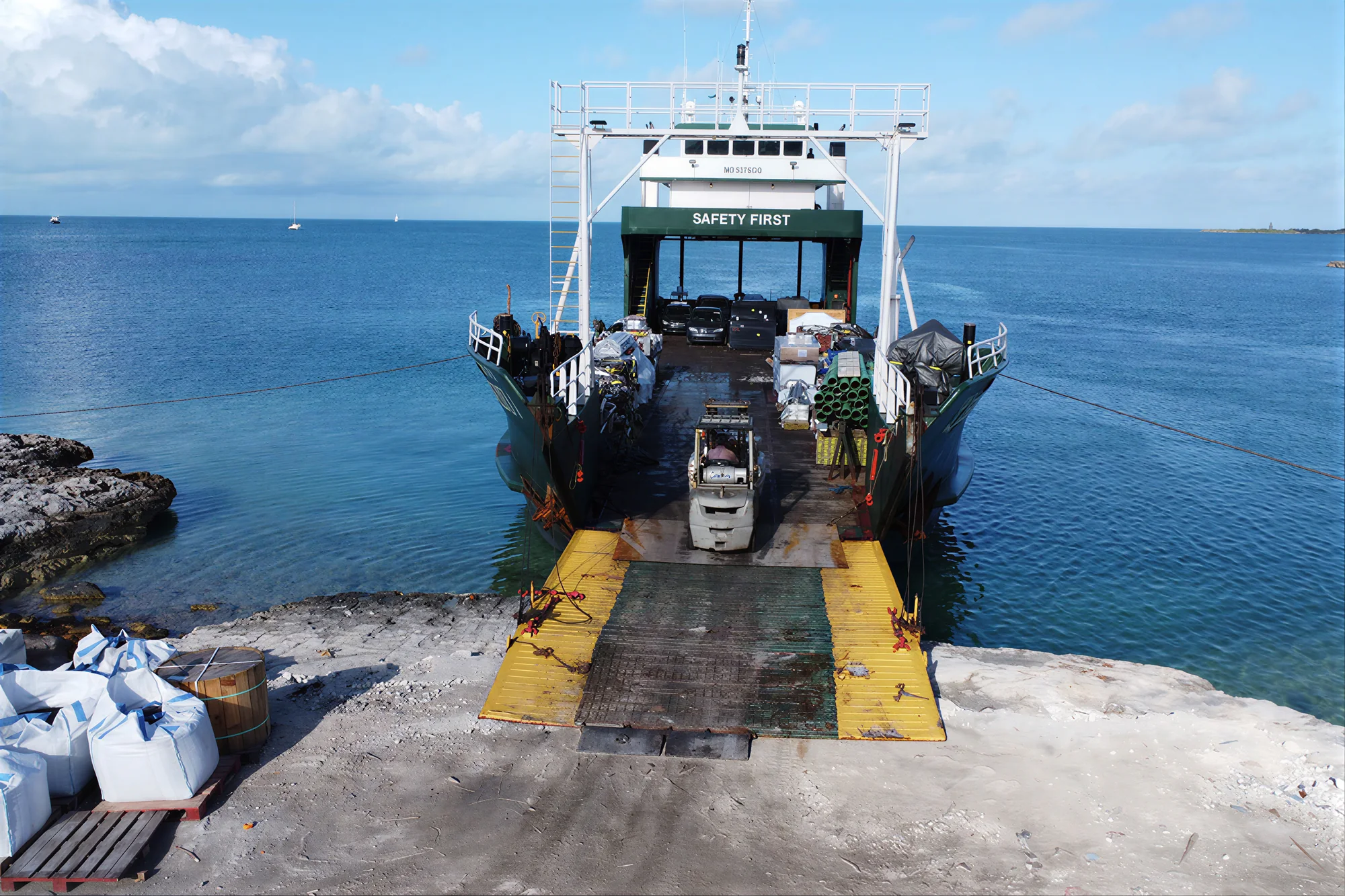 A vessel's ramp down on an island landing, equipment rolling off
